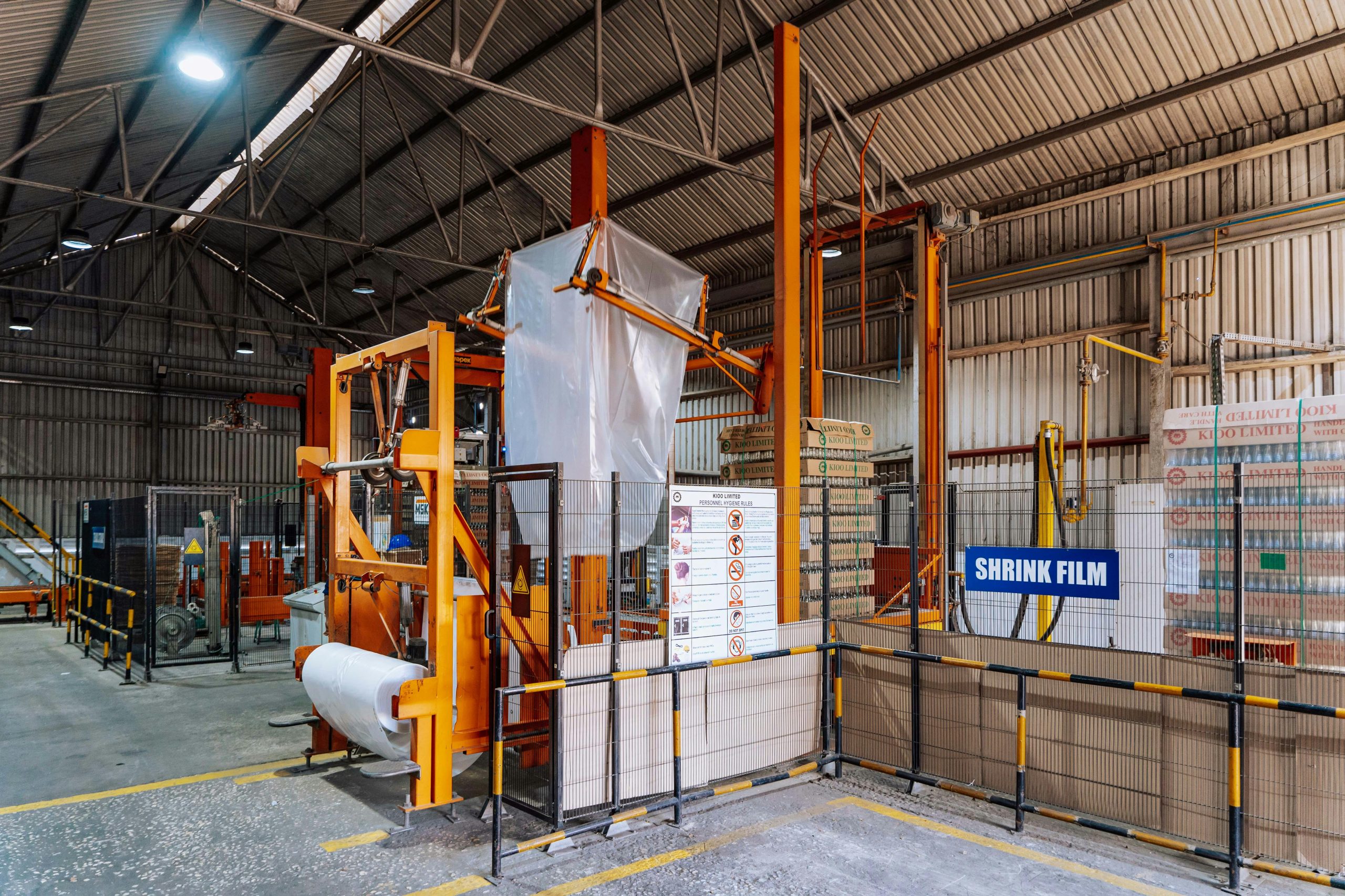 Interior view of a warehouse in Dar es Salaam with a shrink film machine and industrial equipment.